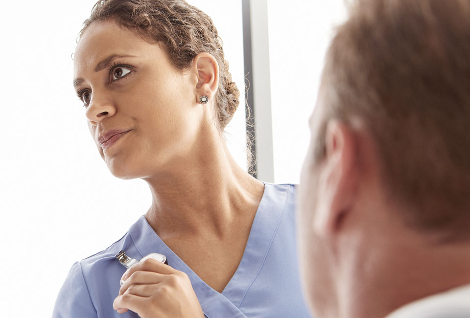 Close up photo of nurse looking left, pressing badge button