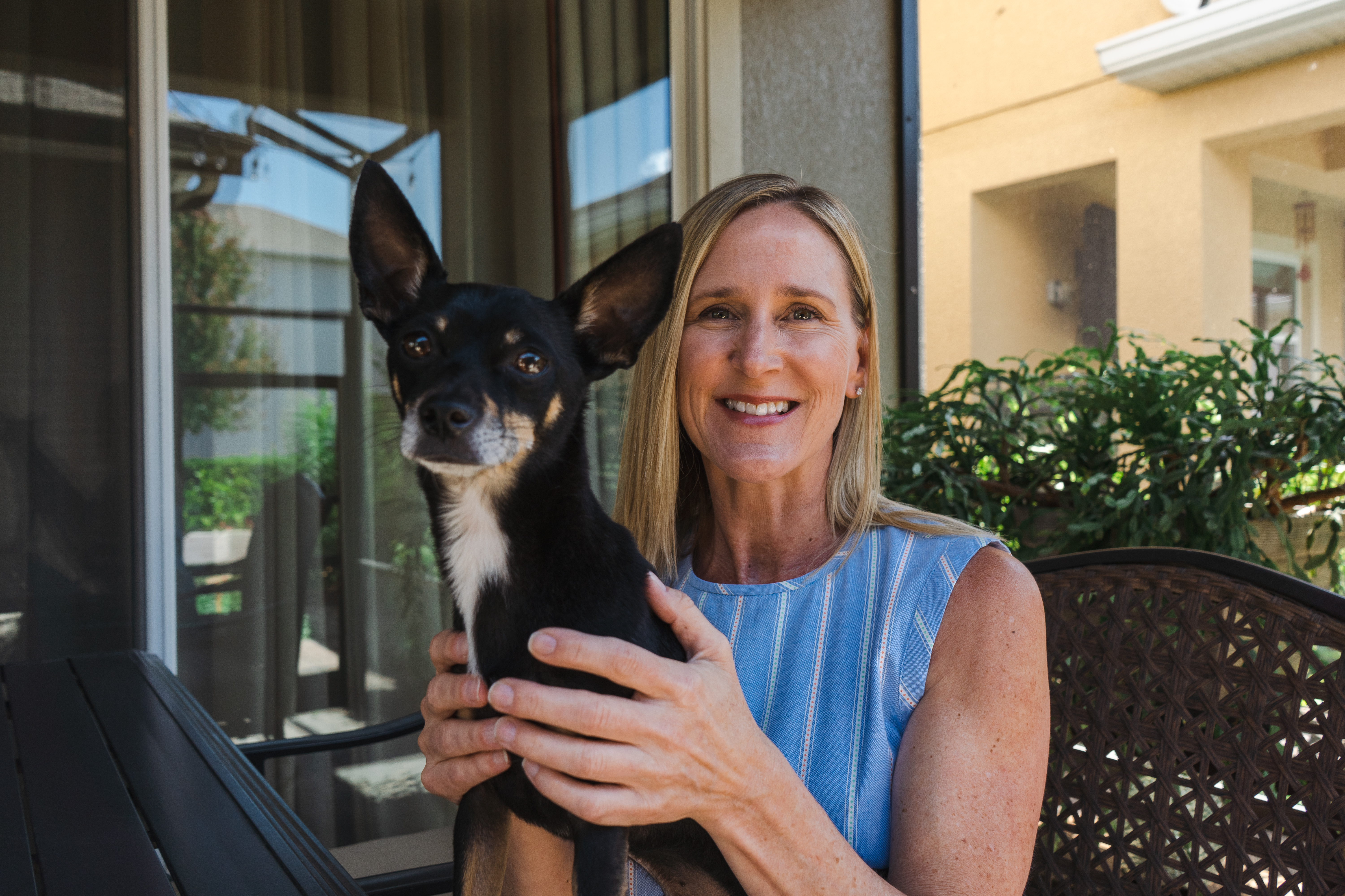 woman holding dog and smiling