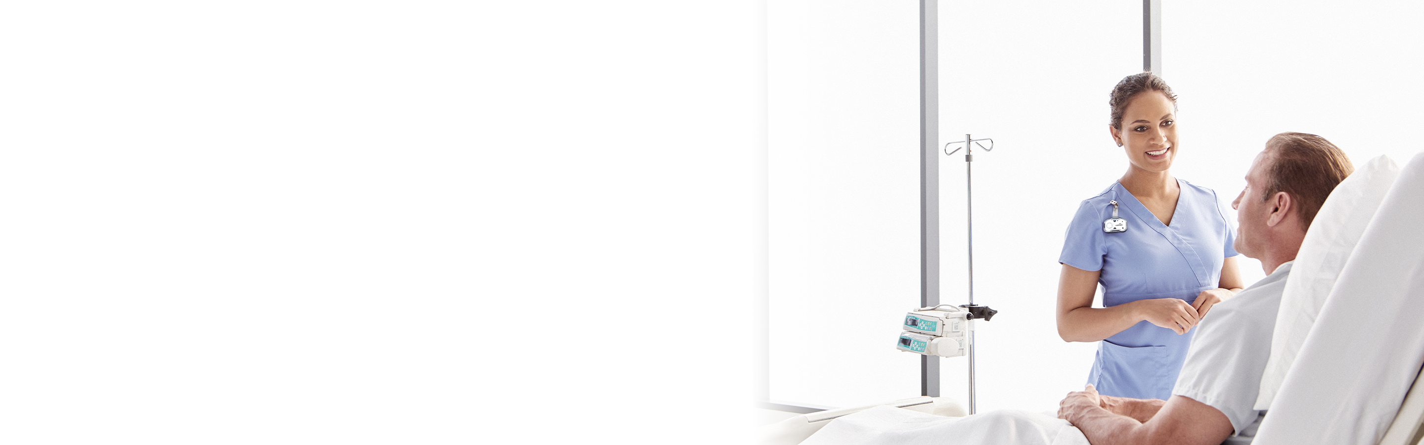 a nurse in blue scrubs wearing a midmark white clearview badge while talking to a patient