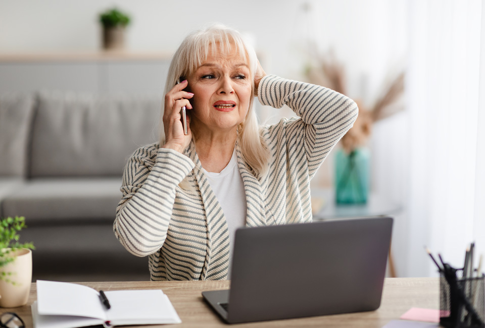 Concerned looking woman in front of laptop making an appointment call