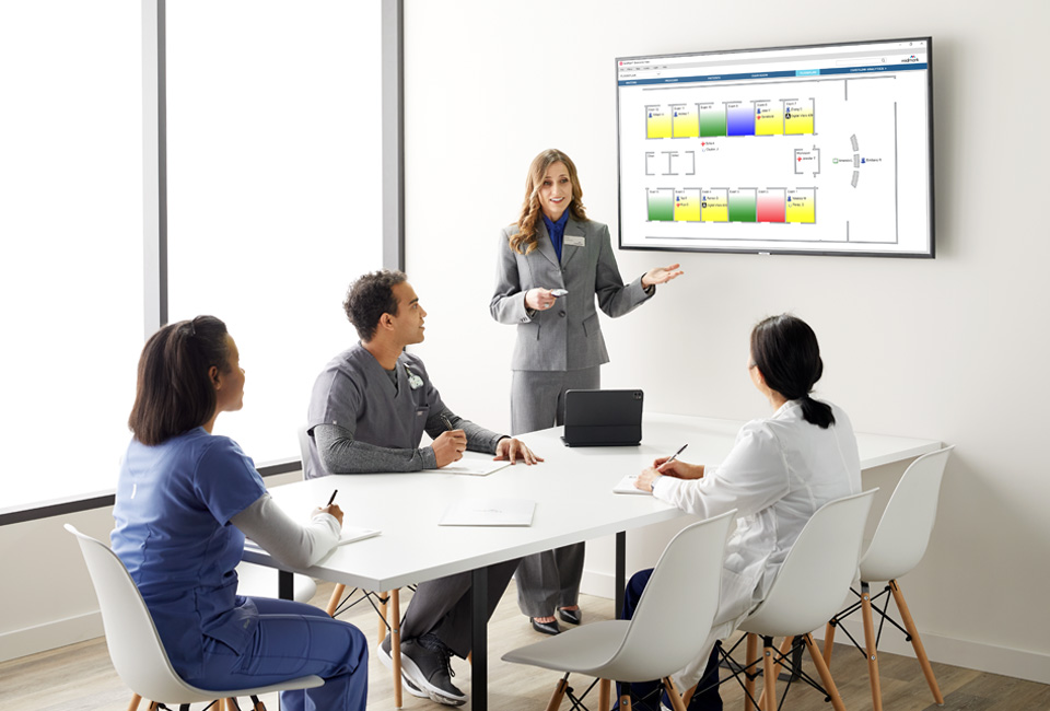 RTLS Customer Success Teammate showing an RTLS badge to doctors and nurses in a training room.