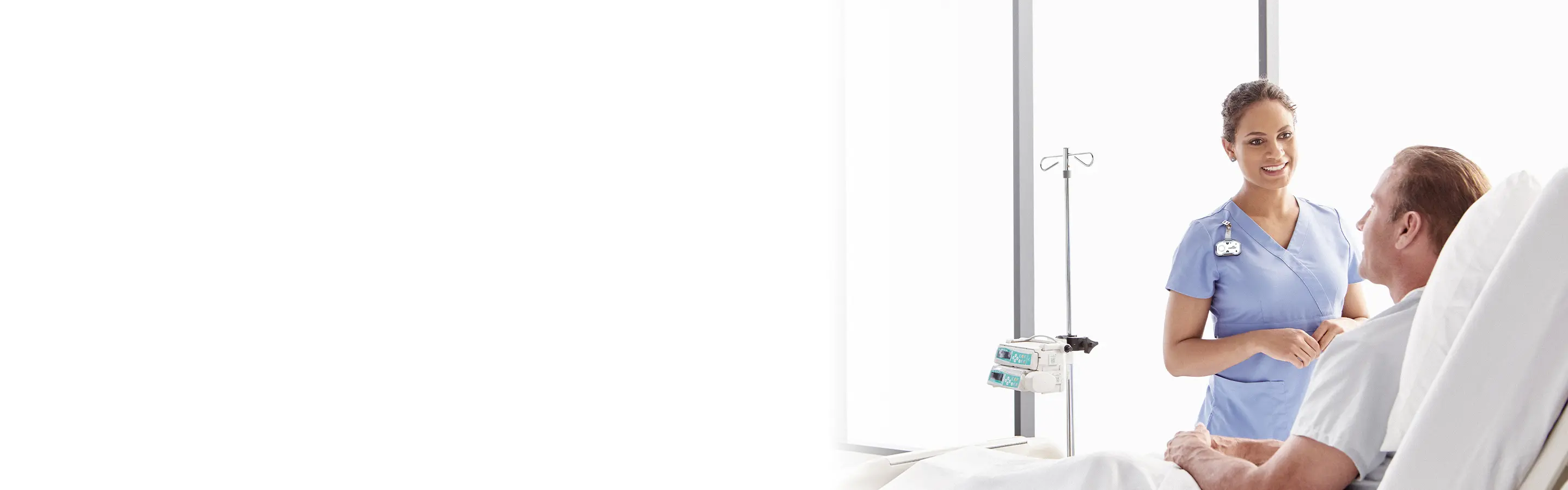 a nurse in blue scrubs wearing a midmark white clearview badge while talking to a patient