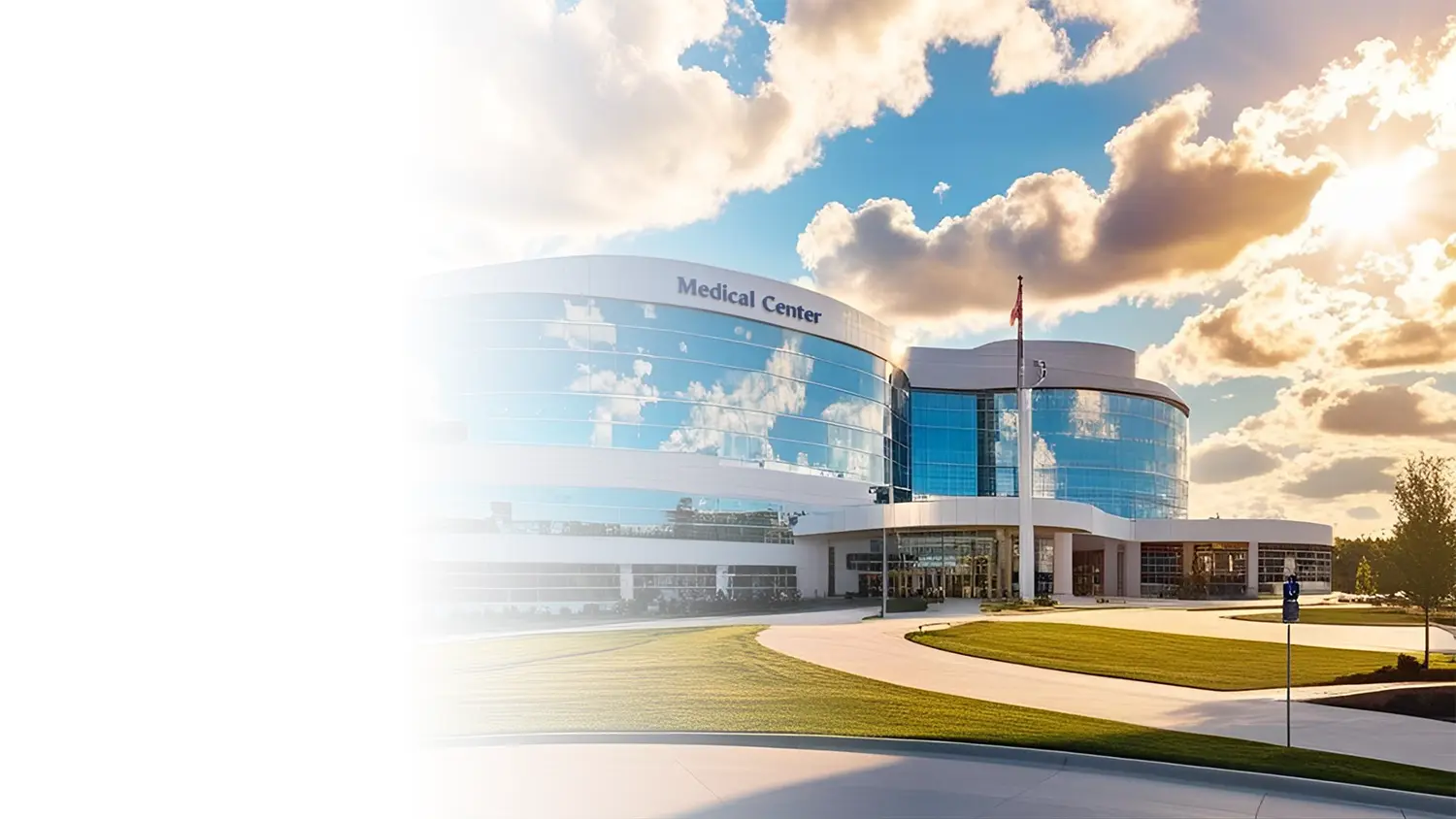 Medical Center with blue skies, clouds, sidewalk and grass.