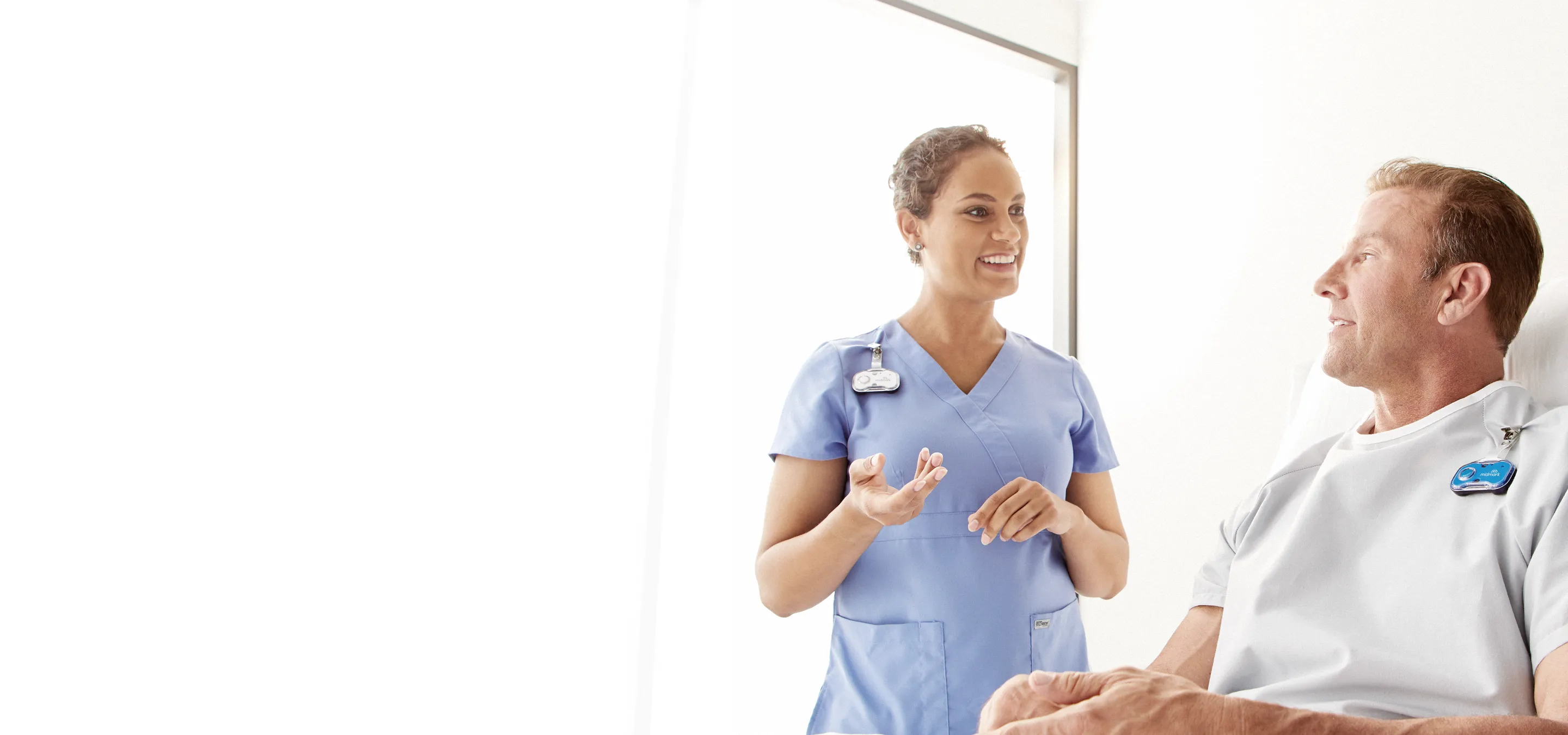 nurse and patient talking and both wearing midmark badges