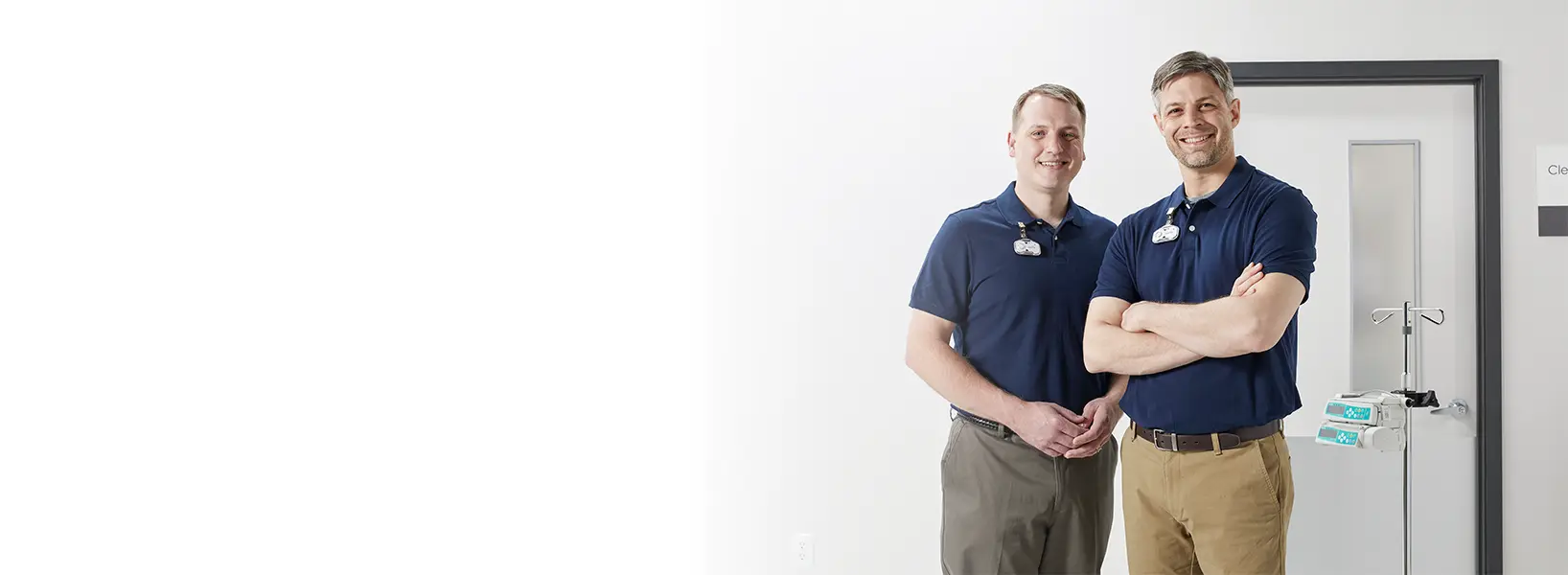 two hospital staff members wearing midmark rtls badges