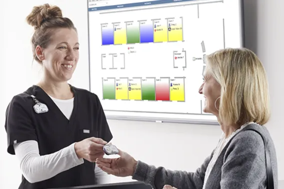 nurse handing patient a midmark rtls badge
