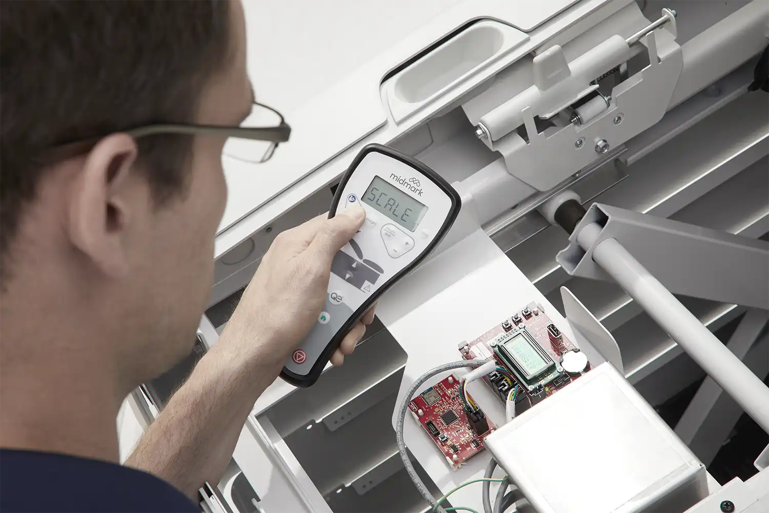 Man with glasses servicing Midmark machine