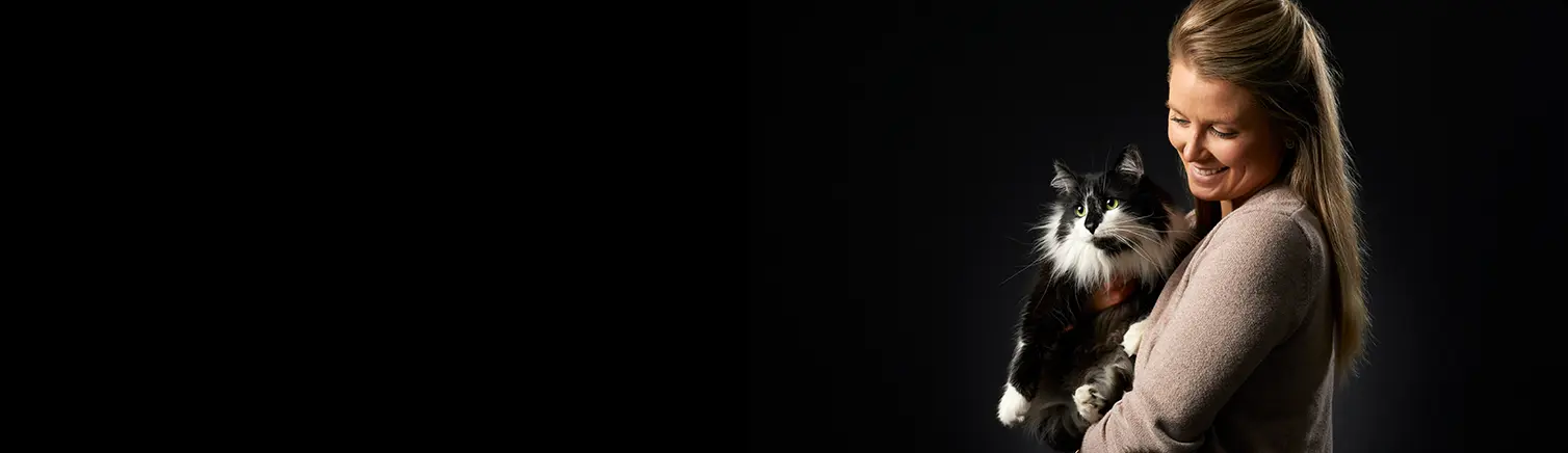 person holding black and white cat