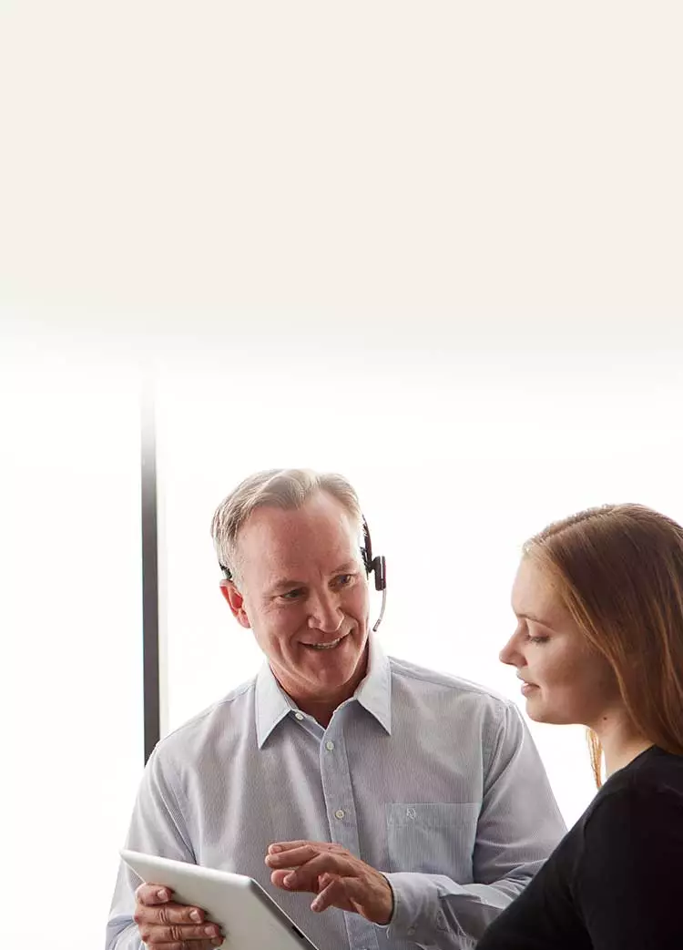 man talking to woman while holding tablet