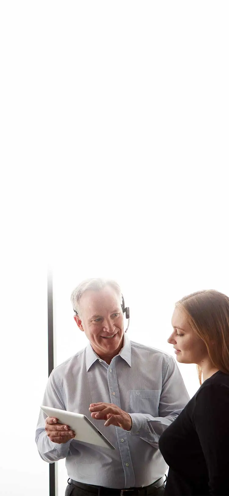 man holding a tablet and talking to a woman