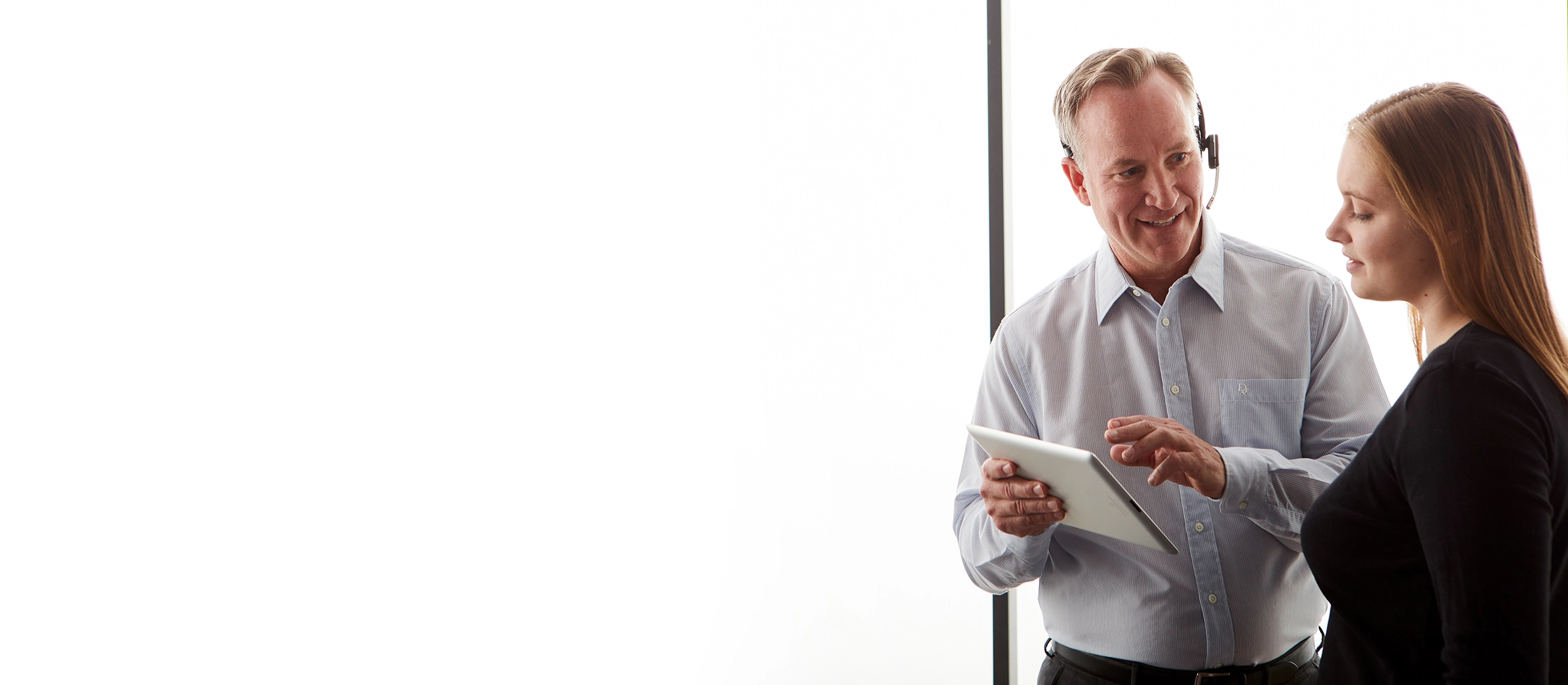 man holding tablet while talking to woman