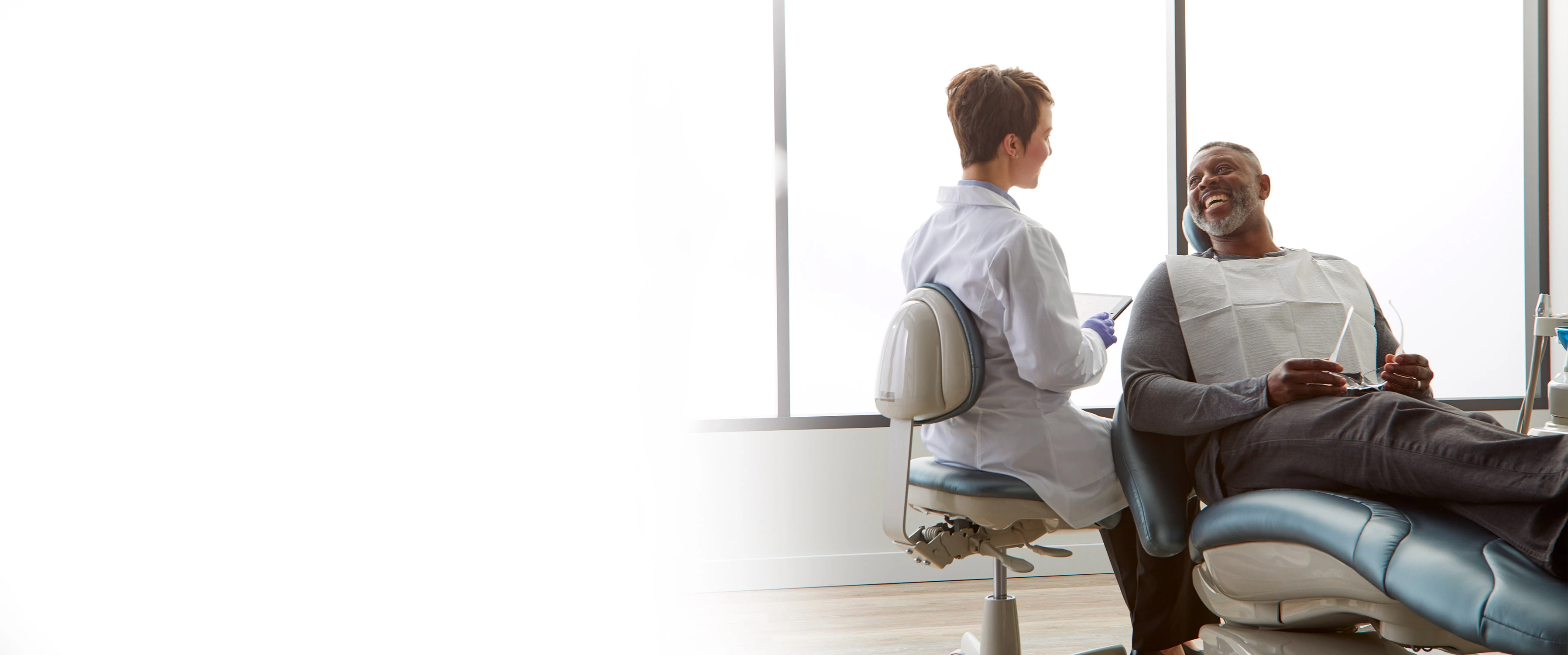 dentist helping patient sitting in midmark dental chairs