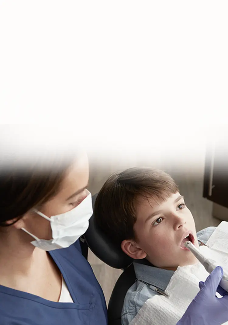 dental assistant cleaning patient's teeth