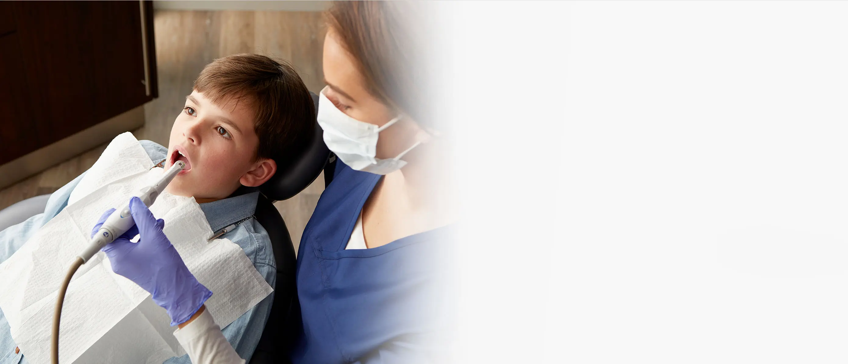 dental assistant cleaning patient's teeth