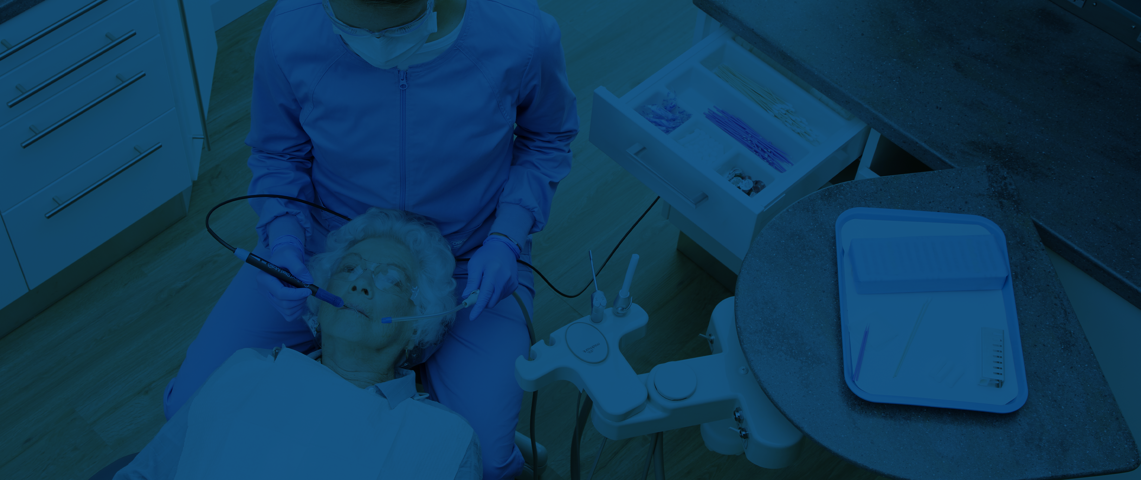 Dental Assistant cleaning Woman's teeth