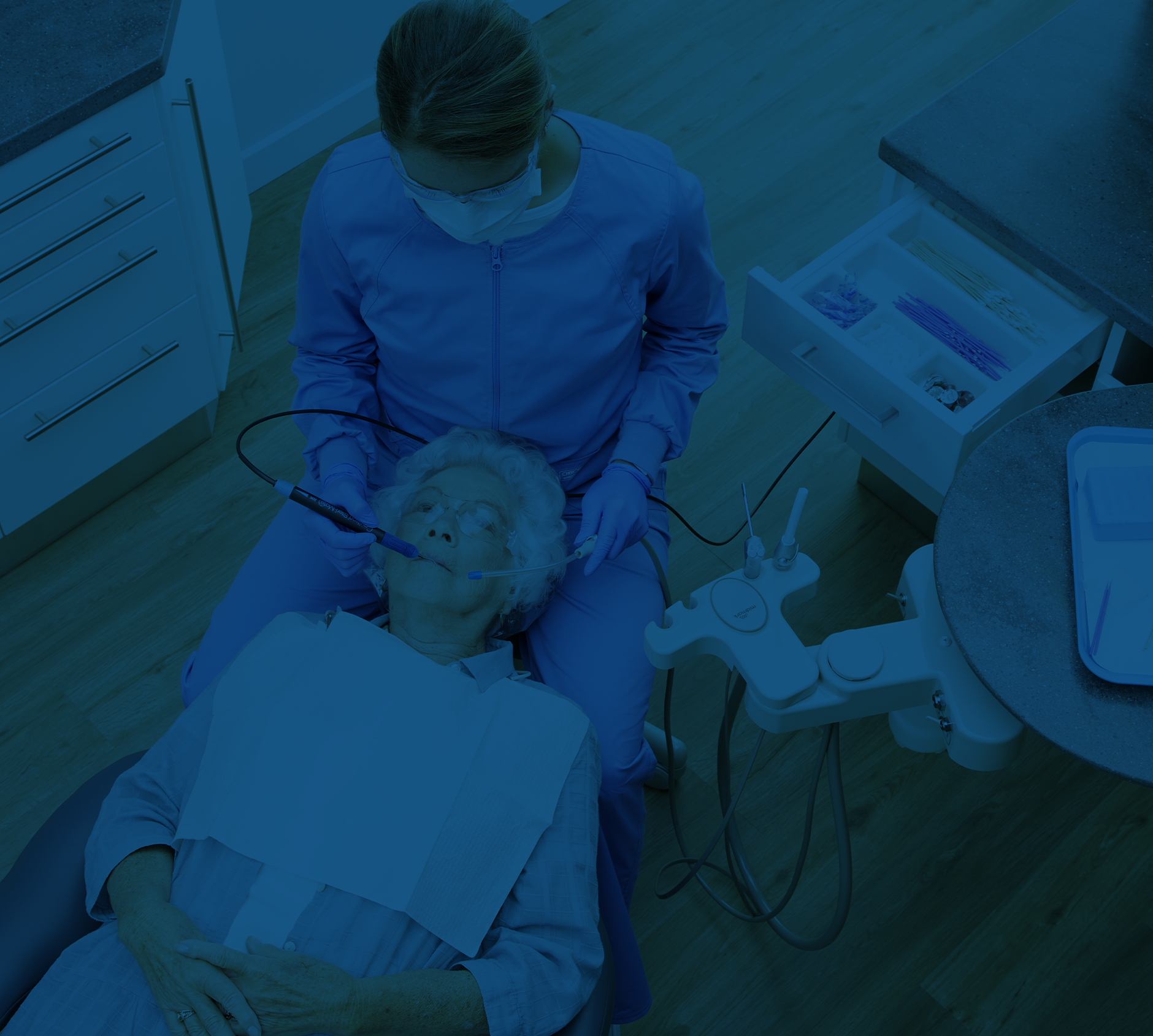 Dental Assistant cleaning Woman's teeth