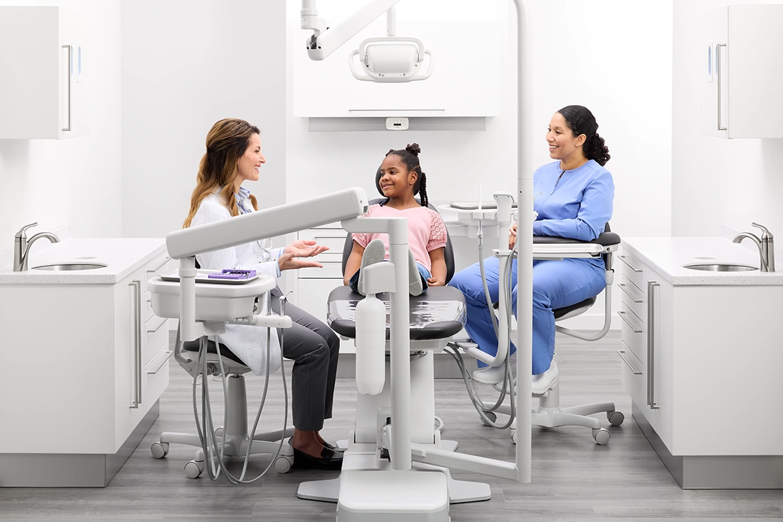 Pediatric patient seated in a Midmark Dental Chair with dental team members in a modern operatory.