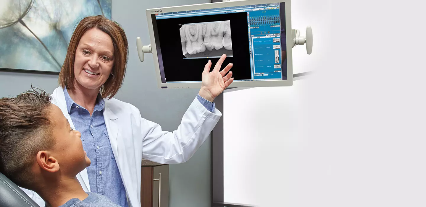 dentist showing x-rays to a child patient