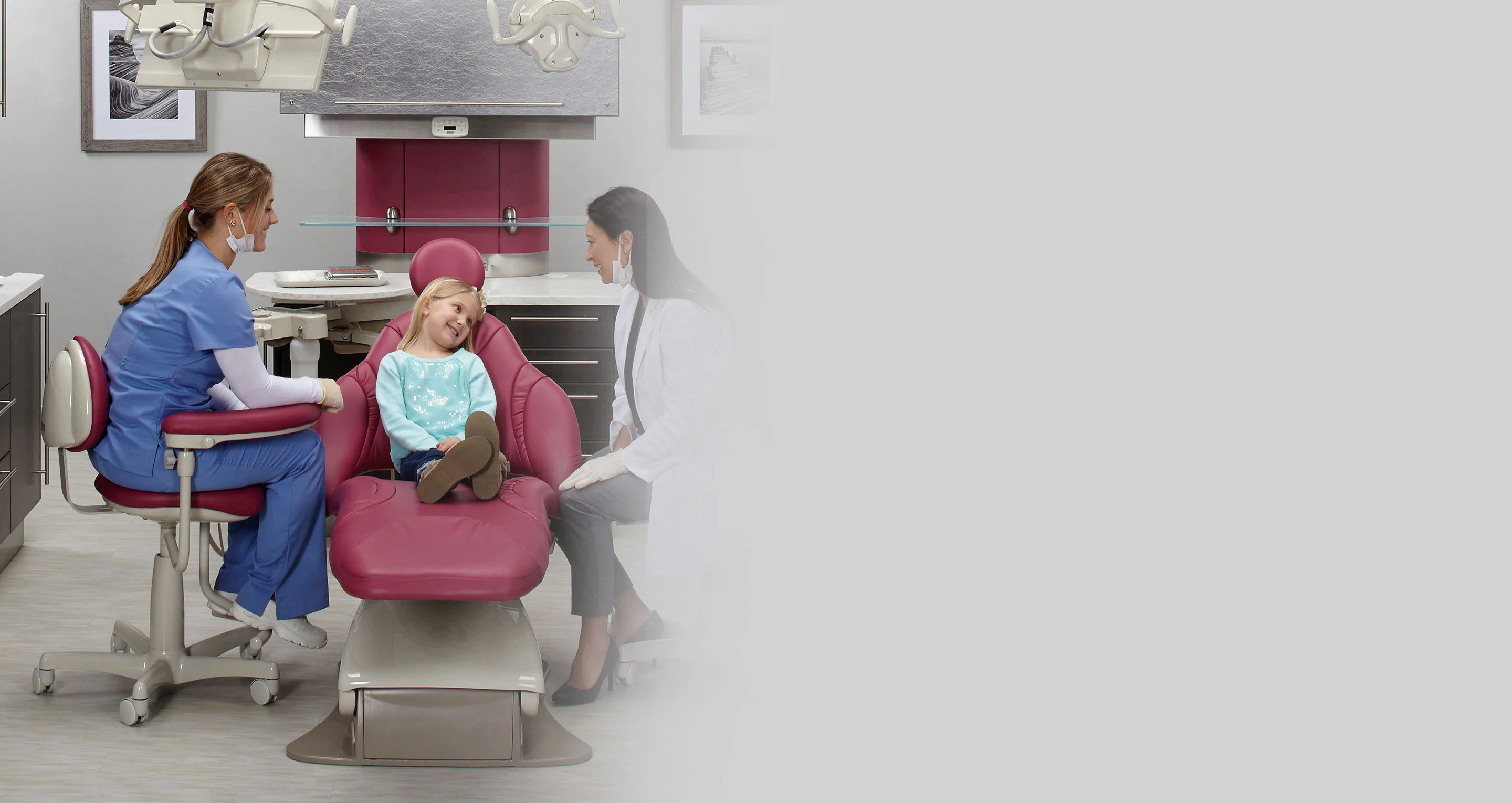 dentist talking to girl in dental chair