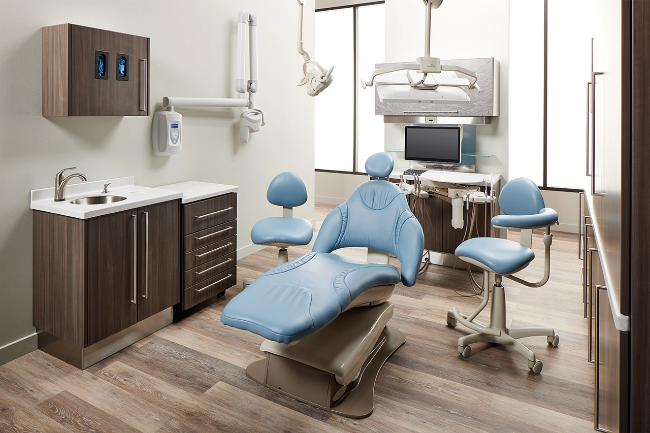 Woman with dark hair, white coat and stethoscope smiling at a woman with dark hair, pulled back