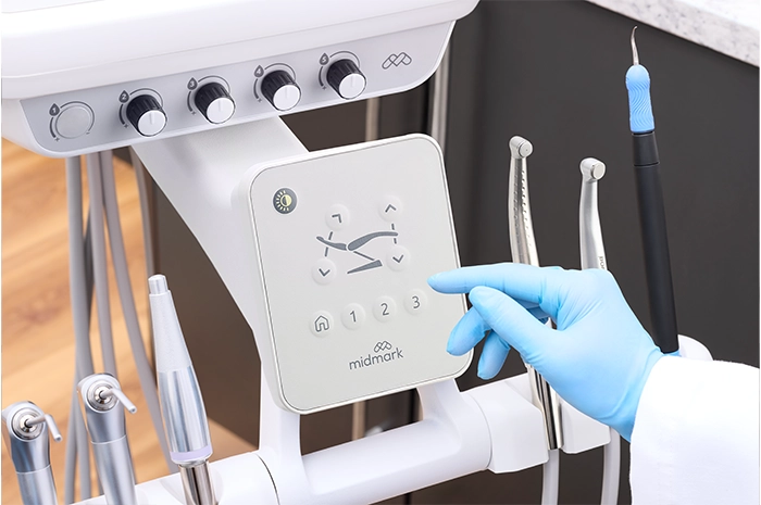 ProductPage-MidmarkDeliverySystem-img2-high-back-detail-dentist-using-touchpad-handpieces-set
