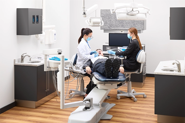 ProductPage-MidmarkDeliverySystem-img9-high-overhead-dentist-hygienist-adult-patient-procedure-rotated-position-touchpad-handpieces-set