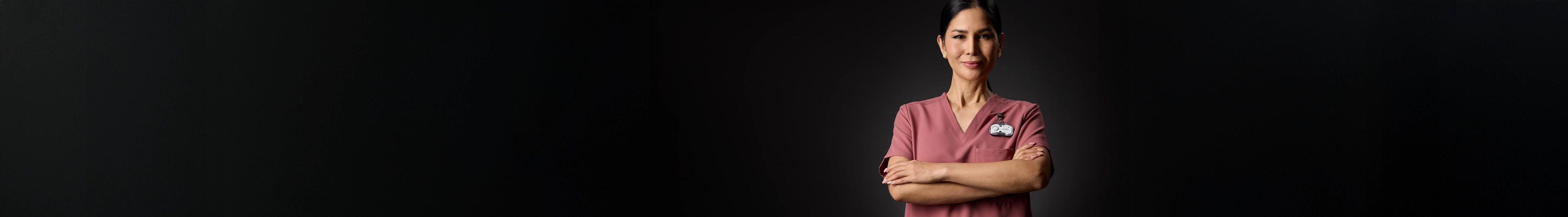 Nurse in red scrubs crossing her arms