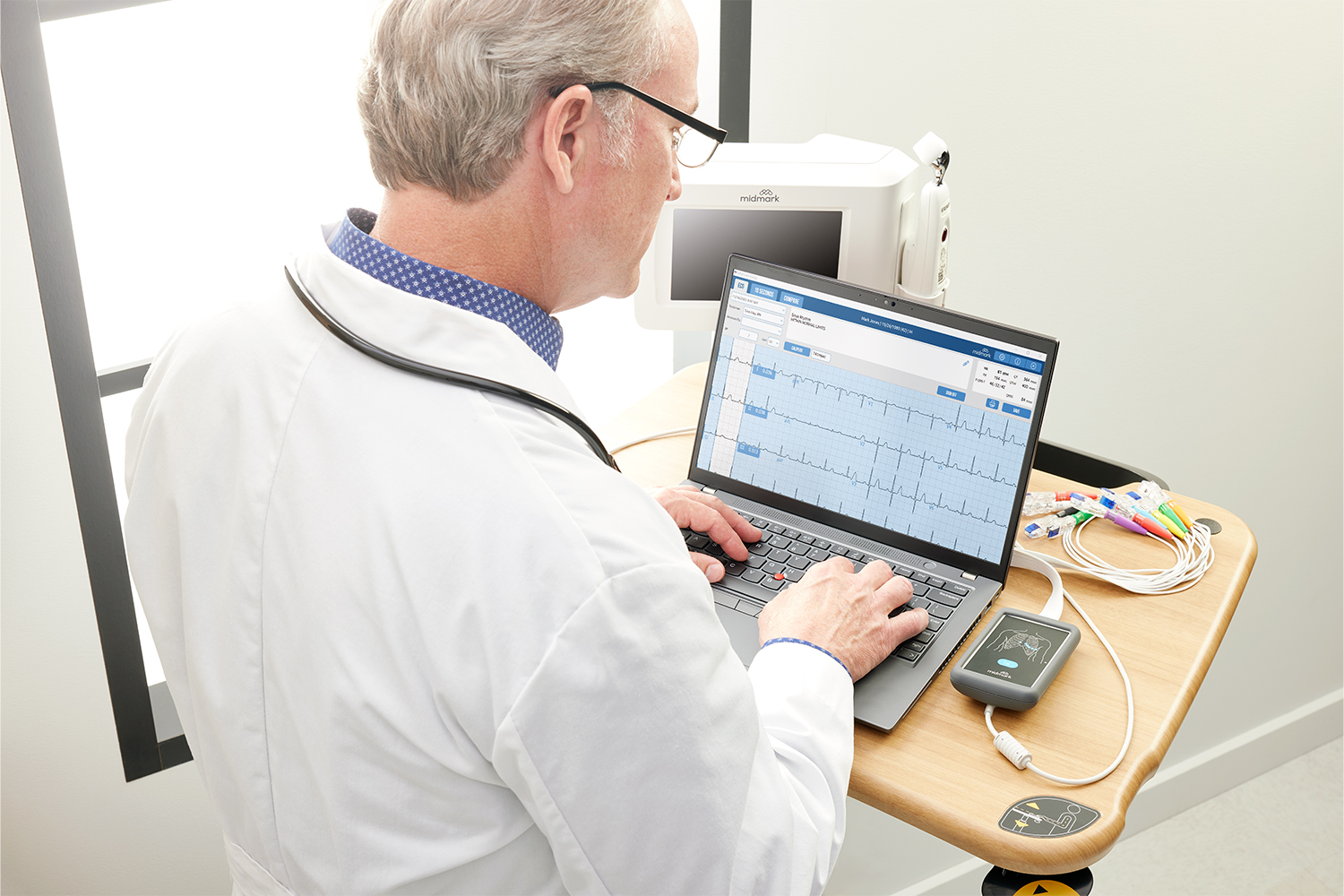 Doctor using laptop to review patient EMR data