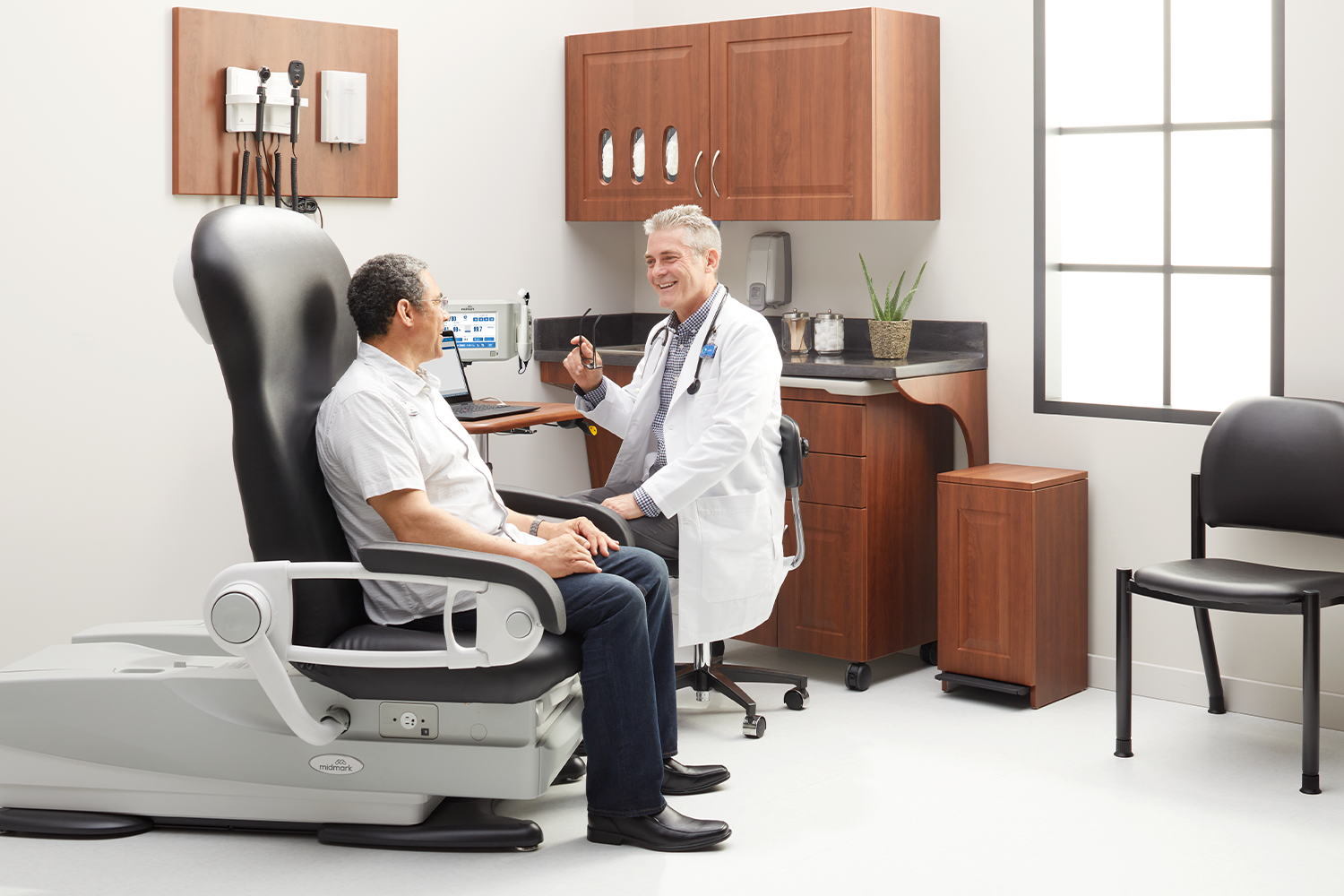 Doctor talking with patient sitting in Midmark 626 Exam Chair