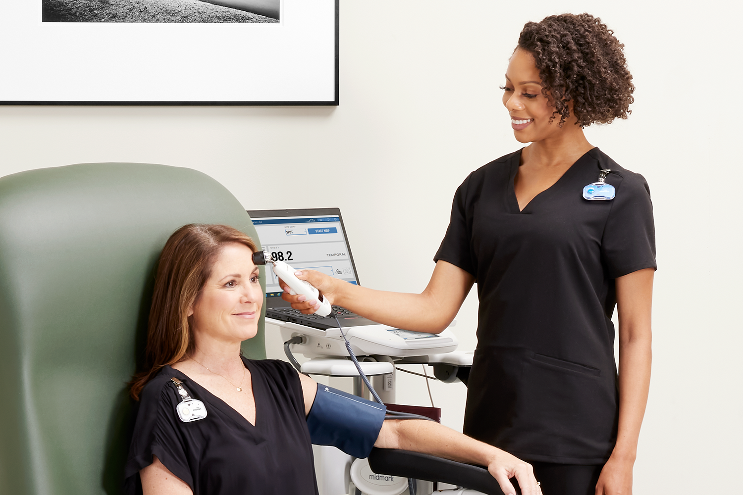 MA taking patients temperature with Exergen thermometer